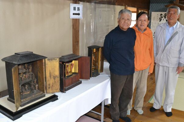 足利雷電神社で「再発見」された仏像３体と氏子総代の斎藤さん（右端）ら