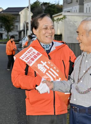 街頭演説会場に訪れた有権者とがっちり握手する針川佐久真氏＝11日午後、日光市所野