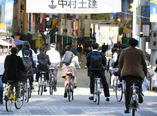 自転車に乗る学生ら＝４月下旬、宇都宮市江野町