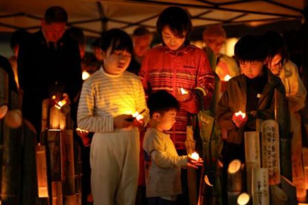 熊本地震の「前震」から10年となり、発生時刻に黙とうする子どもら=14日午後9時26分、熊本県益城町
