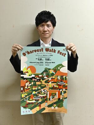 イベントのポスターを持つ市の担当者
