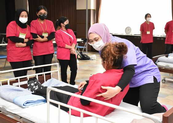 足腰に負担の少ない介助方法を学ぶ外国人職員＝16日午後、宇都宮市砥上町
