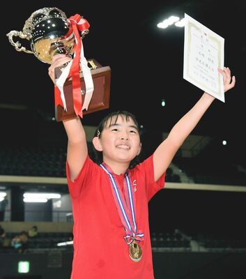 県勢初の日本一に輝き、賞状、優勝カップを掲げて喜ぶ石崎（上三川クラブ）＝２日午後、日環アリーナ栃木