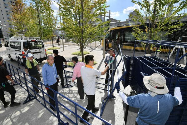 26日の開業に向けて会場周辺の準備を進める関係者ら＝25日午後２時55分、宇都宮市宮みらい