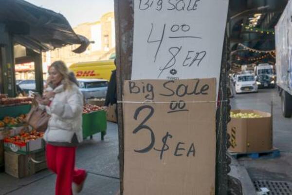 　米ニューヨークの商店街で価格表示の傍らを歩く通行人＝２０２５年１２月１２日（ゲッティ＝共同）