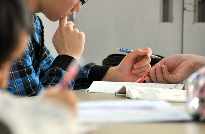ボランティアから勉強を教わる祐汰君。塾に行けない分、ここで真剣に学ぶ＝１月下旬