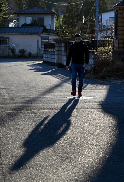 かつて通った、困窮する家庭の子どもや親を支援する居場所へと続く道を歩く一生さん。当時の思いを語り始めた＝2023年12月上旬、日光市内