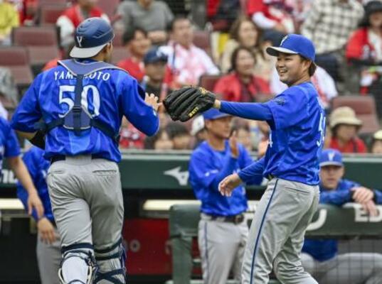 　１回のピンチを切り抜け、笑顔の石田裕（右）と山本のＤｅＮＡバッテリー。６回無失点で今季初勝利を挙げた＝マツダ
