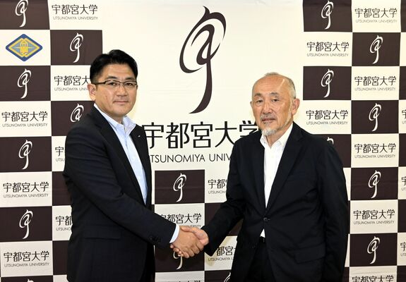 共同研究室開設の記者会見後に握手する池田学長（右）と飯塚社長＝５日午後、宇都宮大
