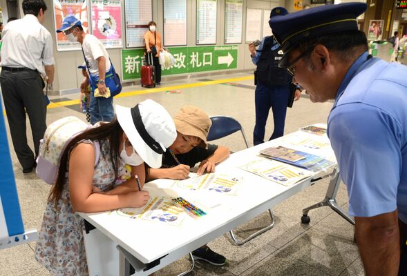 祖父母へ特殊詐欺被害防止のメッセージを書く子どもたち＝８日午前10時５分、ＪＲ宇都宮駅