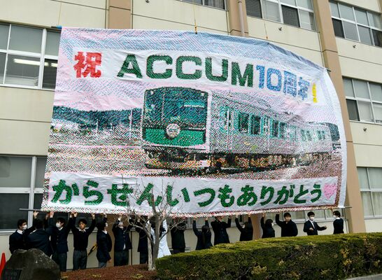 ピクセルアートの掲示作業を手伝う生徒たち