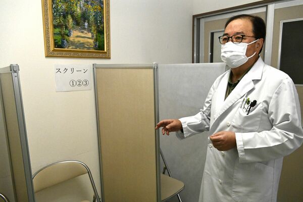 一般患者と接触しないよう廊下に設けたコロナの検査スペースを説明する小沼医師＝20日午後、那須塩原市西朝日町