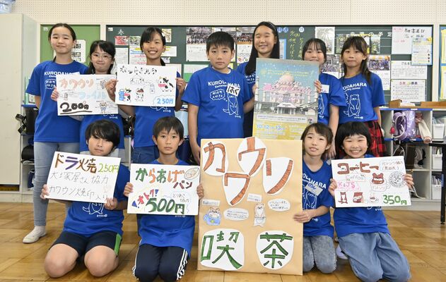 喫茶店をＰＲする看板などを持つ児童たち
