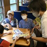 日光明峰高「ぐるめ部」がお手製パンフ配布　SL大樹車内で地元飲食店PR