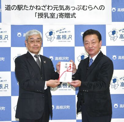 澁谷幹事長（左）から目録を寄贈される加藤町長