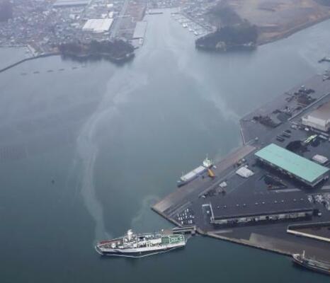 宮城県塩釜市の港に停泊する宮城海上保安部の巡視船「ざおう」(手前)から流出した重油=3月(同部提供)