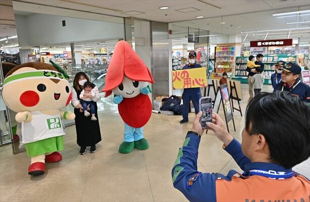 キャラクターと記念撮影する来店客ら