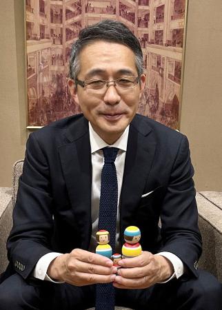 　地域共創企画で作られたヒット商品「ルビンのこけし」を手に取る松屋銀座の古屋毅彦社長