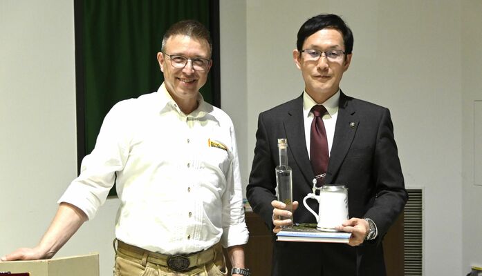 坂村市長（右）へお土産を手渡すフランツさん