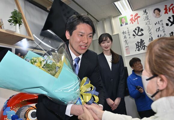 初当選を果たし、花束を受け取る渡辺真太朗氏（左）＝８日午後10時55分、大田原市美原１丁目