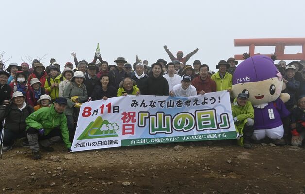釈迦ケ岳山頂で記念撮影する参加者たち