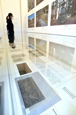 初展示の「墓誌銘銅板」（手前）などが並ぶ会場