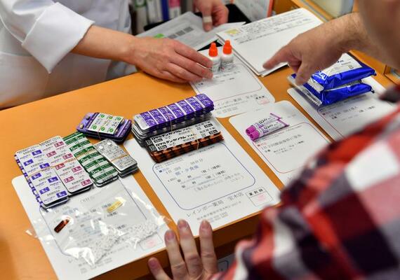 通院後に薬局で薬を受け取る男性。退院から７年ほどたっても、毎日８種類の薬が欠かせなかった＝２０１９年１１月、宇都宮市