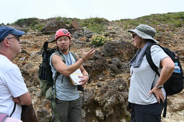 旅行代理店の担当者に那須岳の魅力などを伝える真山さん（中央）＝那須町