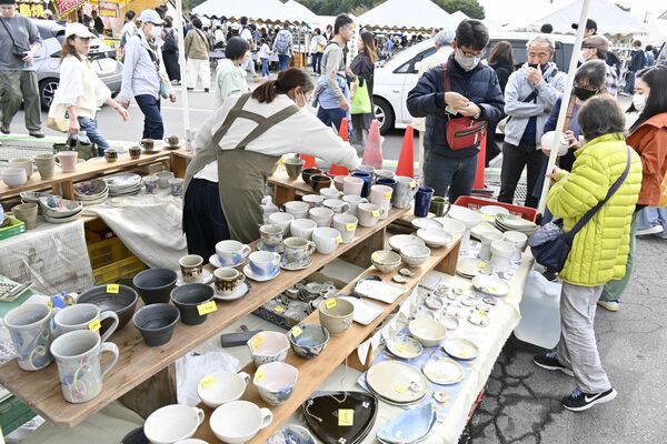 ずらりと並んだ陶器を見定める来場者