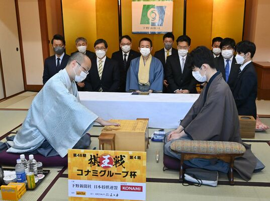 初手を指す渡辺棋王（左）と挑戦者の藤井五冠＝19日午前９時、日光きぬ川スパホテル三日月