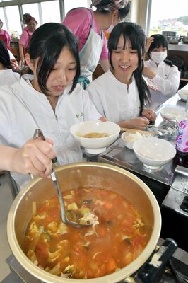 出来上がったビルマ汁をよそう生徒たち
