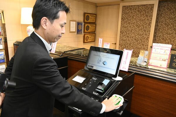 生体認証サービスのデモンストレーションで静脈を読み込ませる関係者＝５日午後、宇都宮東武ホテルグランデ