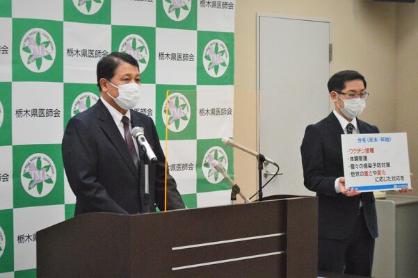 ワクチン接種など感染対策を訴える県医師会の稲野会長（左）＝22日午後、宇都宮市駒生町