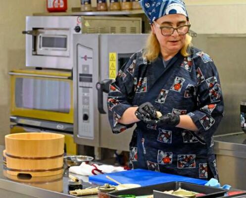 8日、キーウにある国立貿易経済大で、すしの握り方を実演するラリサ・バルスカさん(共同)