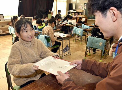冬休みを前に担任教諭から通知表を受け取る児童＝25日午前11時45分、芳賀町祖母井