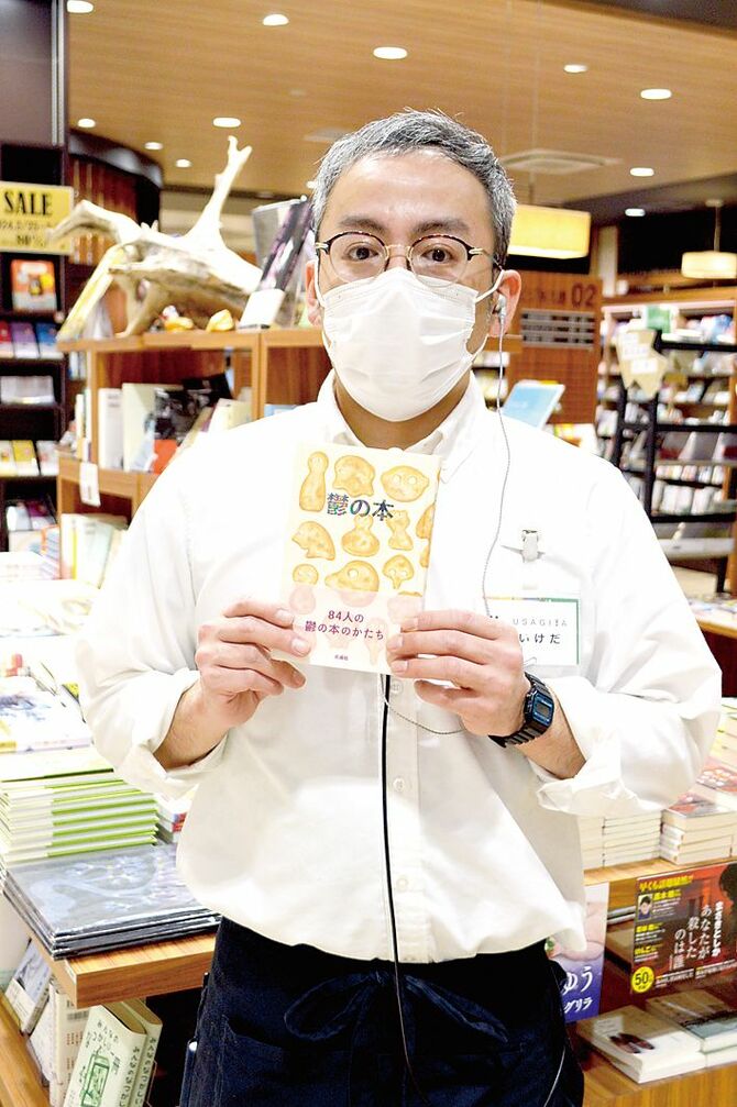睡眠前にお薦めの本を手にする同店書籍担当の池田さん