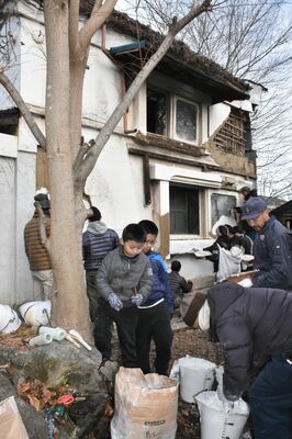 民泊施設となる土蔵の漆喰の中塗りに協力する市民有志やその家族