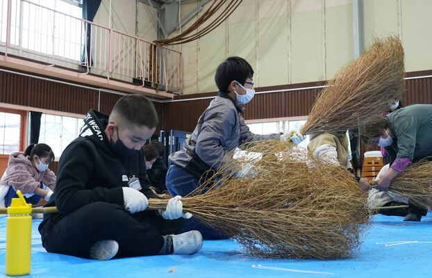 ほうき作りを体験する児童たち