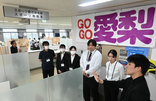 職場見学で職員から説明を聞く参加者ら