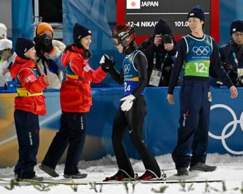 　混合団体　２回目の飛躍を終え、丸山希（左から２人目）らとタッチを交わす二階堂蓮＝プレダッツォ（共同）