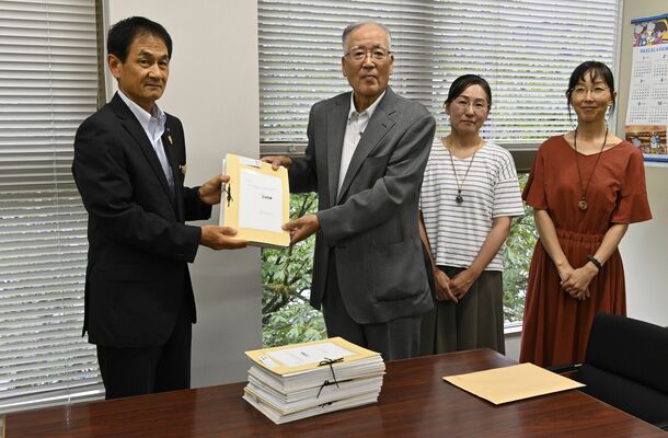 阿久澤県教育長（左）に署名を手渡す宇田会長＝22日午後、県庁南別館