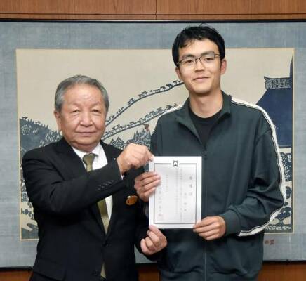 広田町長から委嘱状を受け取り笑顔の白川さん（右）