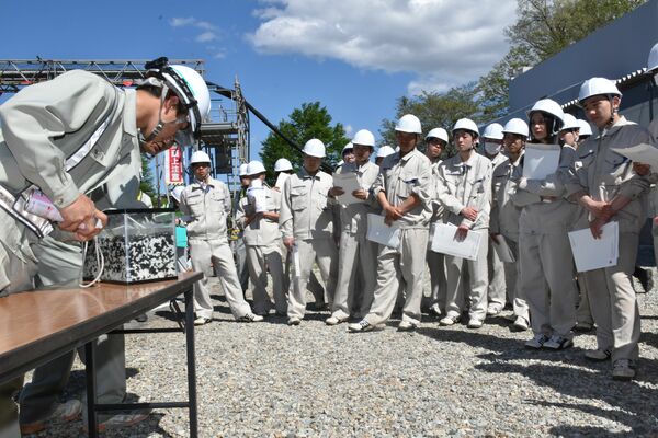 工事現場で橋梁下部工事の説明を聞く生徒たち
