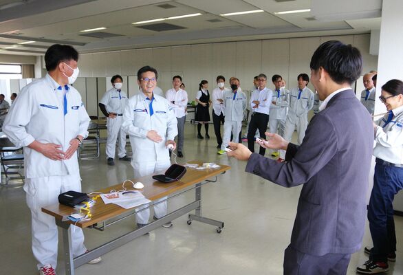 装置を使って生理痛を疑似体験する参加者ら＝26日午後、宇都宮市