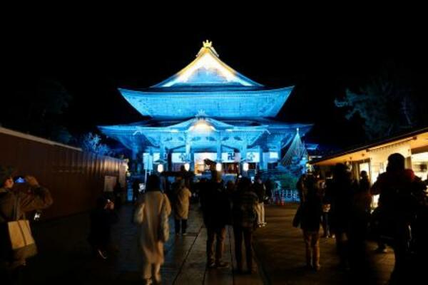 地球を表現した「碧色」にライトアップされた善光寺=20日夜、長野市