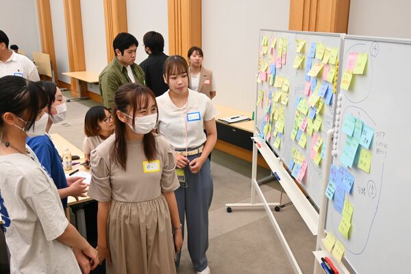 各自のアイデアが書かれた付箋を確認する参加者＝19日午後、県庁
