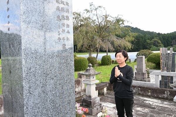 豪雨災害から10年がたち、悦史さんの墓前で手を合わせる裕子さん＝27日午後３時、日光市内