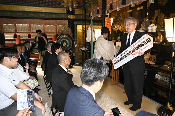 献上祭を終え、日光東照宮御札を手にする西堀社長＝日光市
