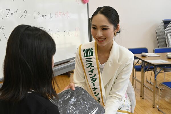 書道セットを子どもに手渡す八鍬さん