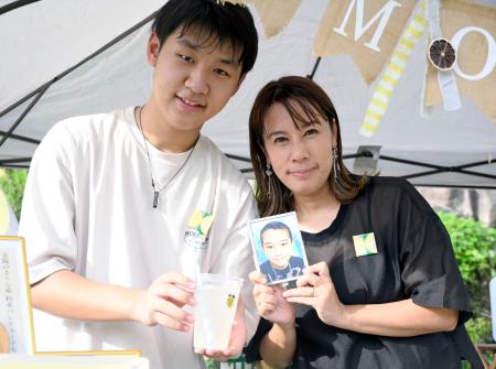 　小児がん患者支援のためにレモネードを販売する土井颯大さん。右は亡くなった大地さんの写真を持つ母のかおりさん＝大阪市鶴見区